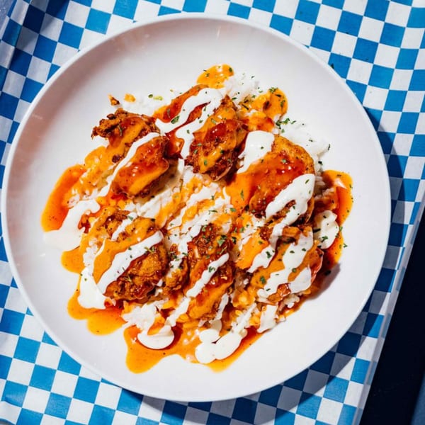 Shark Boy Fish and Chips: fried shrimp with orange and white sauces, garnished with herbs.