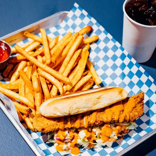 Shark Boy Fish and Chips fried fish sandwich with coleslaw, fries, ketchup, and a drink.